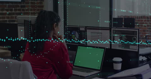 Woman Analyzing Financial Data on Computer Screens in Modern Office