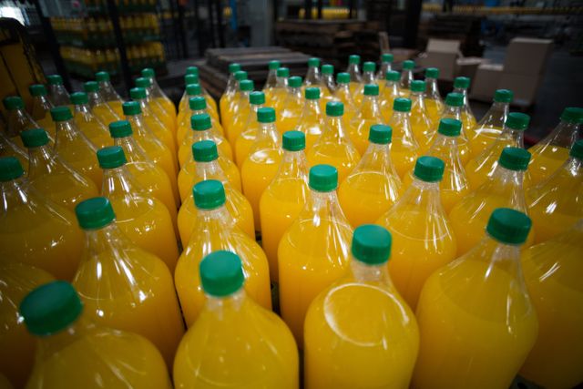 Close-up of juice bottles arranged in rows at factory