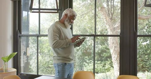 Senior man using tablet in modern home office