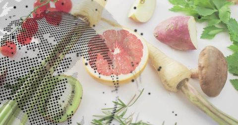 Halftone flatlay of halved pink grapefruit, avocado, herbs and fresh vegetables