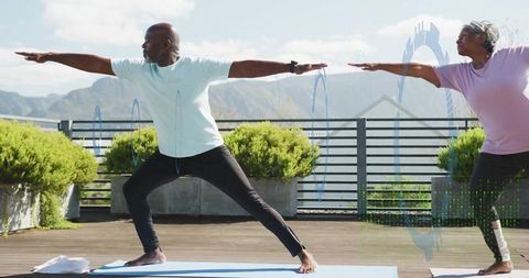 Mature Couples Practicing Warrior II Pose on Rooftop Terrace