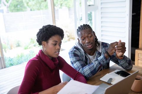 Focused colleagues collaborating on documents outdoors