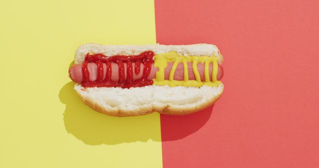 Image of hot dog with mustard and ketchup on a yellow and red surface. food, cuisine and catering ingredients.