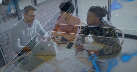 Diverse team collaborating over laptop and wireframe overlays for product design strategy