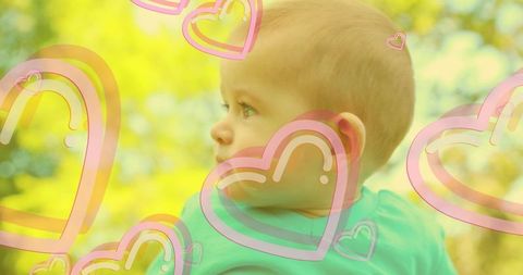 Joyful baby with hearts overlay embracing early development