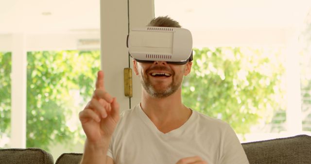 Excited Young Man Wearing VR Headset and Interacting with Virtual World on Couch - Download Free Stock Images Pikwizard.com