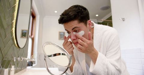 young man applying under eye masks for skincare routine - Download Free Stock Images Pikwizard.com