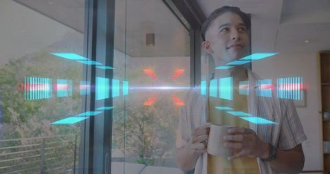 Young Man Holding Mug and Viewing Futuristic Augmented Reality Hologram Through Glass Door