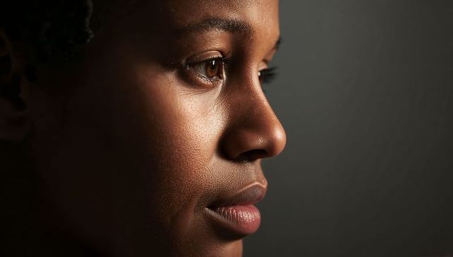 Close-up profile showing contemplative adult woman with glowing skin and eye catchlight