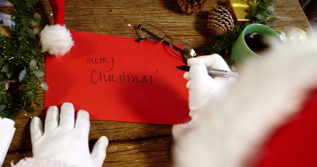 Santa Claus Writing Merry Christmas Card on Wooden Table - Download Free Stock Images Pikwizard.com