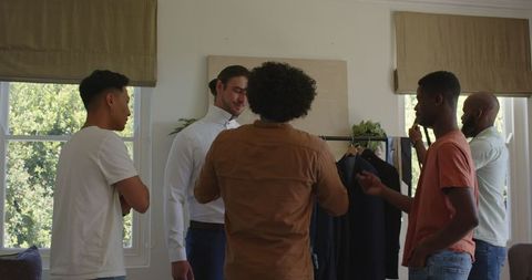 Friends Preparing Groom for Wedding Day with Attire Adjustments
