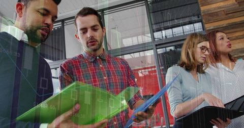Professionals analyzing data charts and collaborating with folders in modern office
