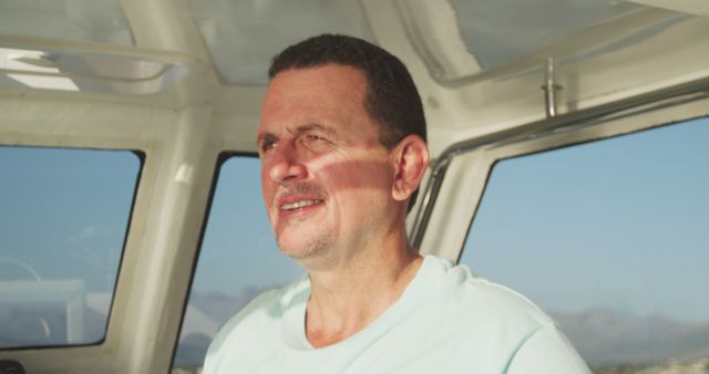 Depicts man relaxing in boat cabin on sunny day. Ideal for use in vacation promotions, travel blogs, advertisements, adventure-themed materials, and articles focusing on leisure and outdoor activities.