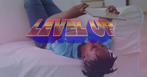 Boy relaxing on couch using tablet with 'level up' text overlay