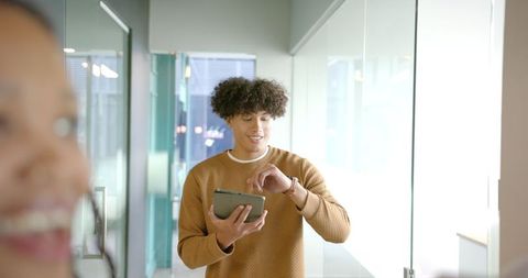 Young Professional Working on Tablet in Modern Office Hallway