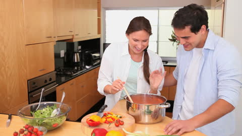 Couple Cooking Together Smiling in Modern Kitchen