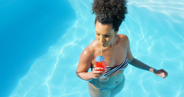 Woman Drinking Cocktail in Pool with Striped Bikini - Download Free Stock Images Pikwizard.com