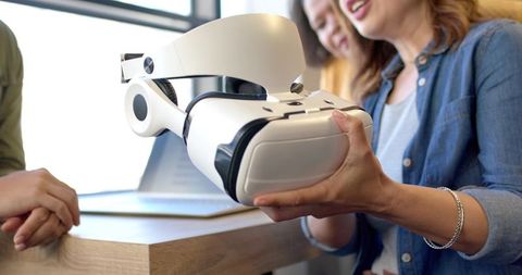 Sharing VR headset during team tech demo and collaboration training in modern office