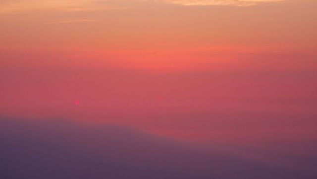 Vibrant sky gradient above clouds at high altitude