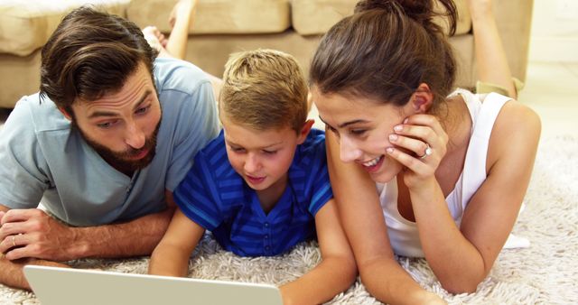 Cheerful Family Spending Quality Time Using Laptop on Carpeted Floor - Download Free Stock Images Pikwizard.com