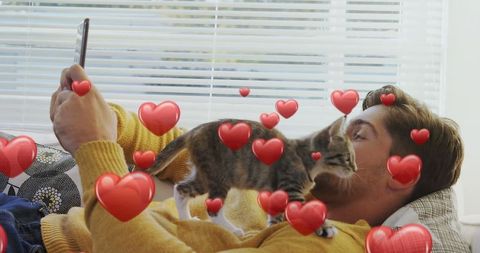 Young Man Relaxing with Kitten While Taking Selfie at Home