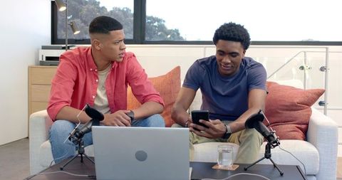 Diverse Friends Collaborating on Podcast with Microphones and Laptop