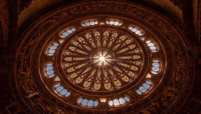 Illuminated gothic stained glass window with intricate sculptures