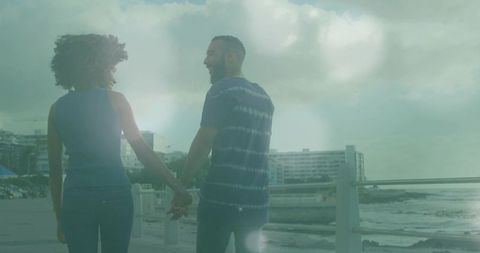 Romantic couple strolling along scenic oceanfront walkway
