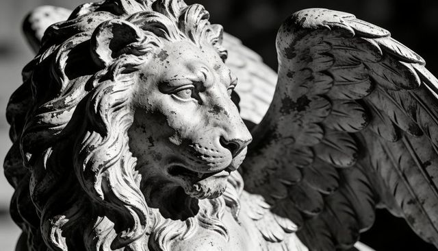 Winged lion sculpture featuring weathered mane and feathered wing in dramatic monochrome