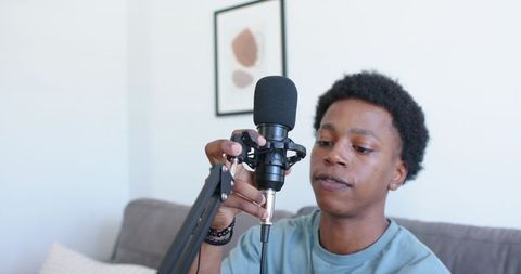 Adjusting podcast microphone on boom arm in home studio recording for content creators