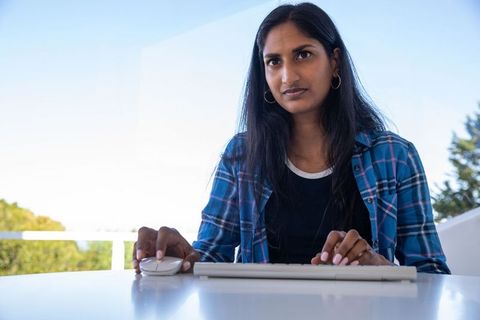 Focused Woman Typing Outdoors on Modern Balcony Workspace