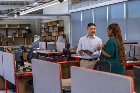Diverse Coworkers Discussing Project in Modern Open-Plan Office