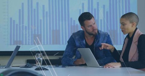 Colleagues analyzing data presentation in modern meeting room