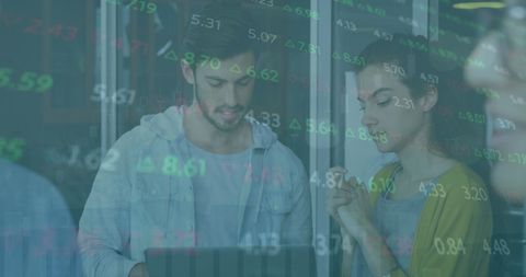 Colleagues Analyzing Stock Market Data Over Laptop Screen