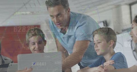 Teacher Guiding Students with Laptop and Overlaying Financial Graph