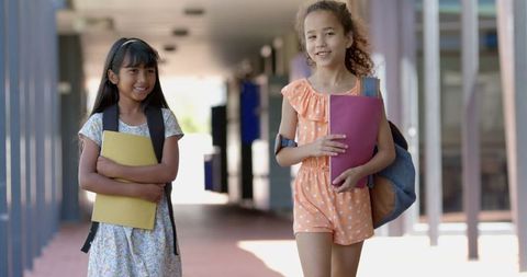 Smiling Biracial Girls Walking in School Corridor with Backpacks - Download Free Stock Images Pikwizard.com