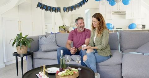 Mature Couple Laughing and Enjoying Birthday Celebration at Home