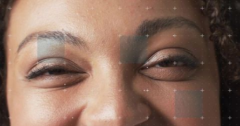 Closeup smiling woman squinting with overlay grid highlighting skin texture and eye makeup