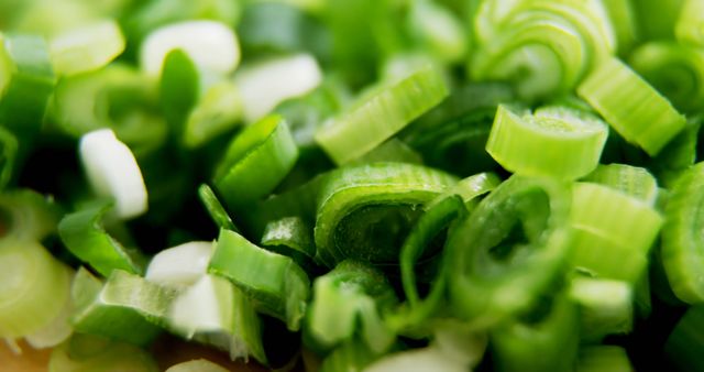 Close-up of freshly chopped green onions, showcasing their vibrant green color. Perfect for illustrating food preparation, healthy eating, or recipes. Suitable for food blogs, cooking websites, and health-related content.