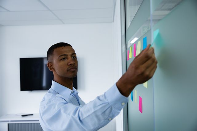 African American business man using sticky notes in office - Download Free Stock Photos Pikwizard.com