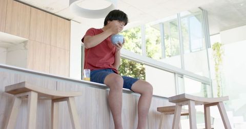 Young man enjoying meal on modern kitchen counter