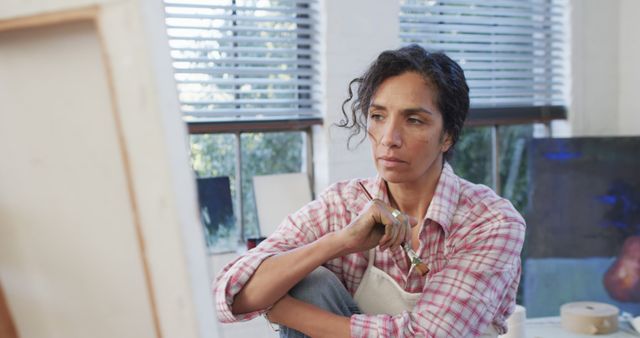 Artist concentrating while painting in bright studio - Download Free Stock Images Pikwizard.com