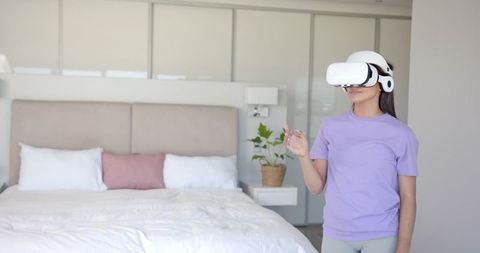 Woman Using VR Headset in Modern Bedroom Setting