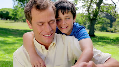 Father and Son Bonding While Using Tablet Outdoors