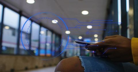 Commuter tapping smartphone with futuristic blue hud overlay displaying transit schedule