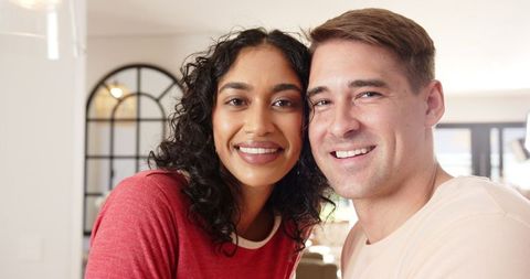 Diverse Couple Smiling in Sunlit Living Room