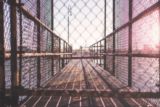 Empty Pedestrian Walkway with Chain Link Fence in Sunlight - Download Free Stock Photos Pikwizard.com