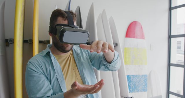 Man using virtual reality headset in surfboard shop - Download Free Stock Images Pikwizard.com