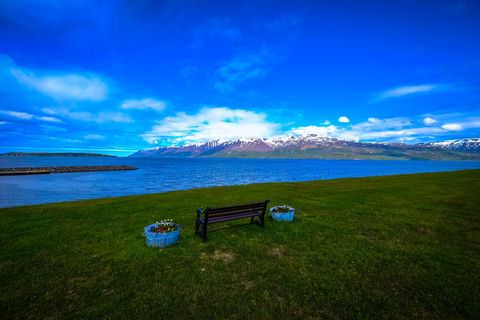Scenic landscape with bench, mountains and blue sky
