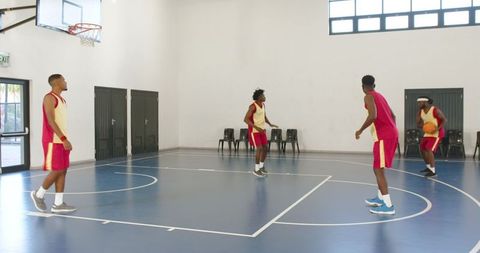 Basketball team training in indoor gym with focus on teamwork